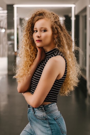 Photo of Woman Standing While Posing in Well-lit Room
