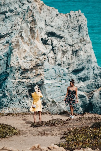 Photo of Woman Taking Photo of Her Friend by Edge of Cliff