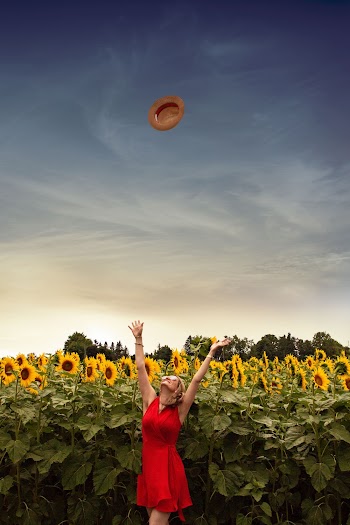 Photo of Woman Throwing Her Straw Hat Upwards