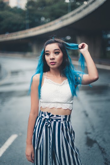 Photo of Woman Touching Her Hair While Standing in the Middle of the Road