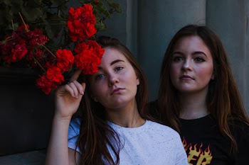 Photo of Woman Touching Red Flowers