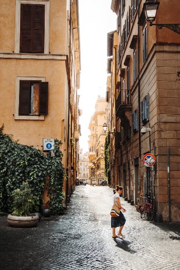 Photo of Woman Walking Between Buildings