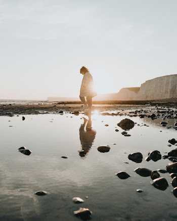 Photo Of Woman Walking On Sea Shore