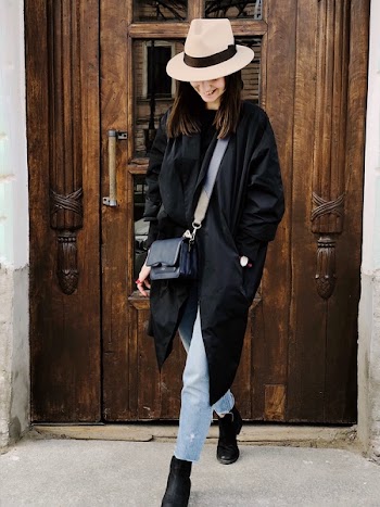 Photo of Woman Wearing Black Coat and Faded Blue Jeans