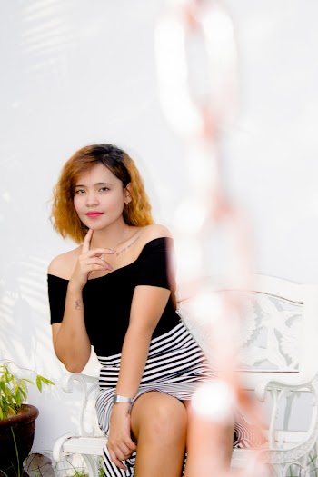 Photo of Woman Wearing Black Off-shoulder Top Sitting Down