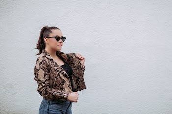 Photo of Woman Wearing Brown-and-black Snakeskin Jacket Beside Wall