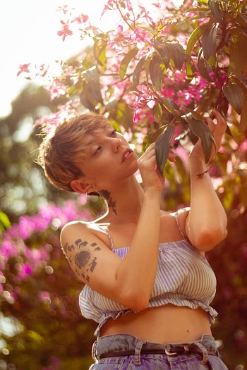 Photo of Woman Wearing Crop Top Holding Leaves