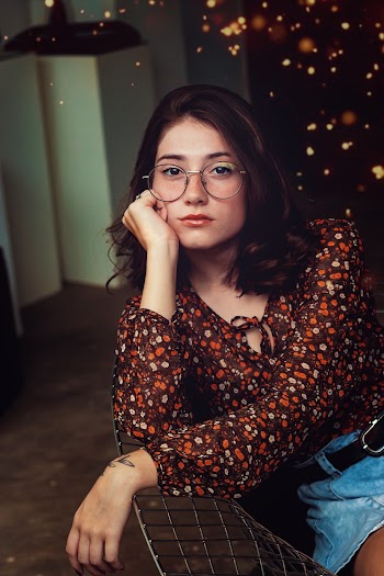 Photo of Woman Wearing Eyeglasses Sitting on Chair