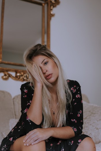 Photo of Woman Wearing Floral Dress Sitting on Couch