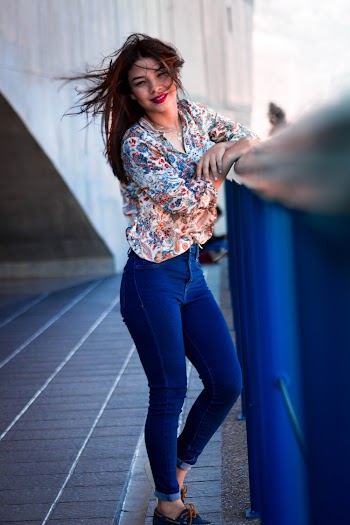 Photo of Woman Wearing Multicolored Floral Long-sleeved Top and Blue Jeans