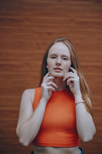 Photo of Woman Wearing Orange Sleeveless Crop Top