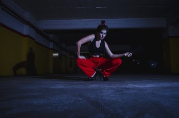 Photo of Woman Wearing Sports Bra and Red Pants