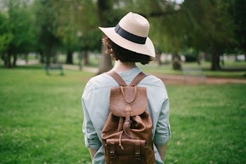 Photo of Woman Wearing Sun Hat and Leather Bag