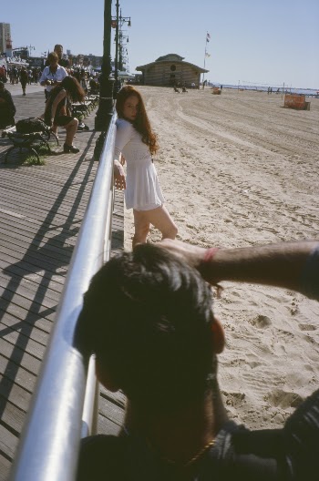 Photo of Woman Wearing White Dress and a Man Taking Photo Using Black Dslr Camera