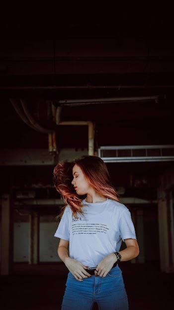 Photo of Woman Wearing White Shirt and Blue Denim Bottoms Flipping Her Hair