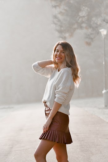 Photo of Woman Wearing White Sweater and Brown Leather Mini Skirt