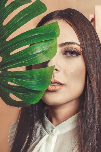 Photo of Woman With Green Leafed Plant Covering Her Right Eye