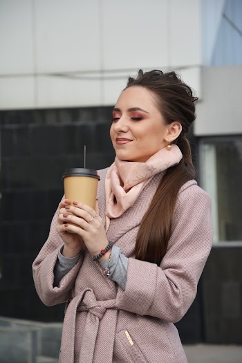 Photo of Woman With Her Eyes Closed Standing Holding a Plastic To Go Cup