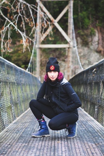 Photo of Woman With Purple Hair Squat Posing in The Middle of a Bridge