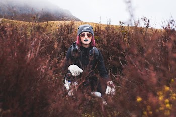 Photo of Woman With Purple Hair Squat Posing in the Middle of Bushes