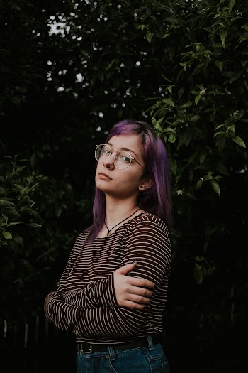 Photo of Woman With Purple Hair Standing With Her Arms Crossed