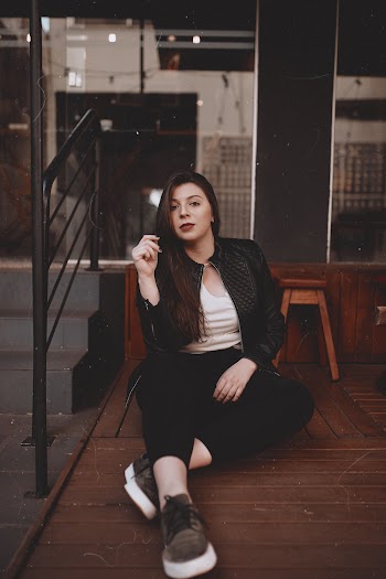 Photo of Woman Woman Sitting on Wooden Floor Near Stairs