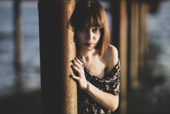 Photo Of Women Leaning On Wooden Post