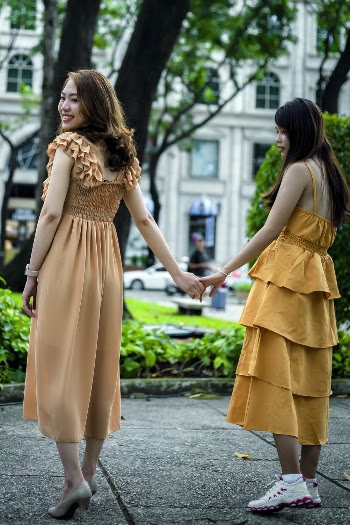 Photo of Women Wearing Dress While Holding Hands