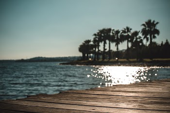 Photo of Wooden Dock and Island Under Gray Sky