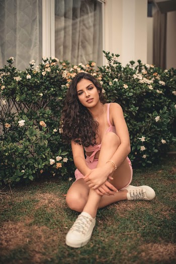 Photo-shoot of Woman Sits Near White and Green Shrubs