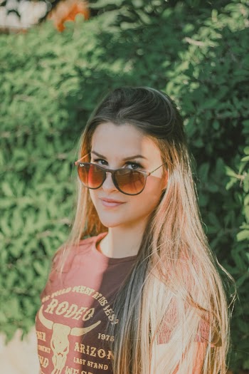 Photo Woman in Brown T-shirt and Sunglasses Standing In Front of Green-leafed Plants