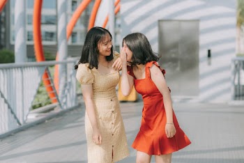Photograph of two women in dresses laughing