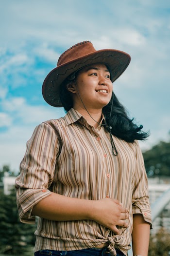 Photograph of Woman in Brown Striped Shirt and Hat