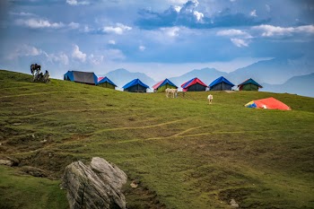 Photographed of Lined Tents on Green Grass Hills