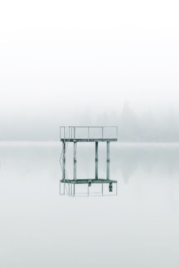 photography gray metal tower near body of water during daytime