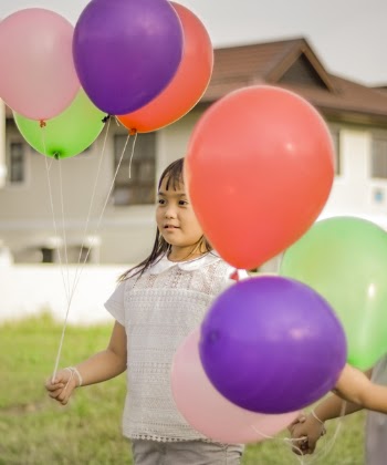Photography of a Girl Holding Balloons