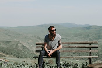 Photography of a Man Sitting on Wooden Bench