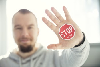 Photography of a Persons Hand With Stop Signage