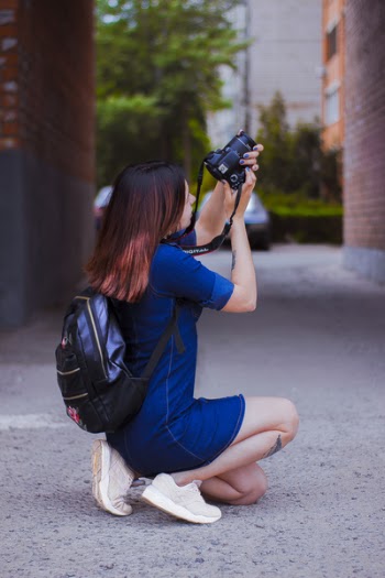 Photography of a Woman Kneeling While Taking a Picture