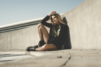 Photography of a Woman Leaning on a Wall