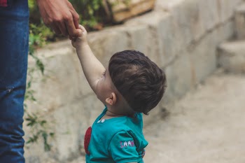 Photography of Baby Holding The Hand of Person