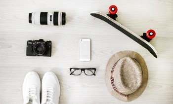Photography of Black Skateboard, White Iphone 5, Brown Hat, Black Point-and-shoot Camera, and Zoom Lens
