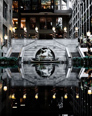 photography of body of water leading to statue and building