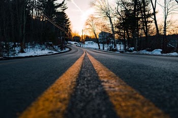 photography of concrete road with snow and tree surround it