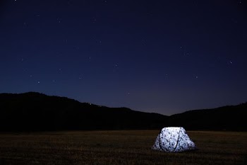 photography of lighted tent on field