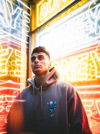 photography of man standing in front of neon sign