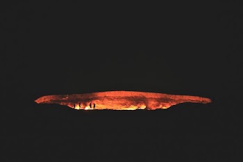 photography of people near cave at night time