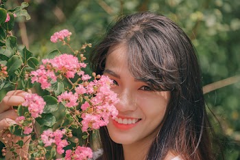Photography of Smiling Woman Near Flowers