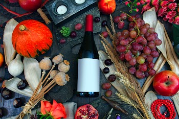 Photography of Wine Bottle on Table Between Fruits