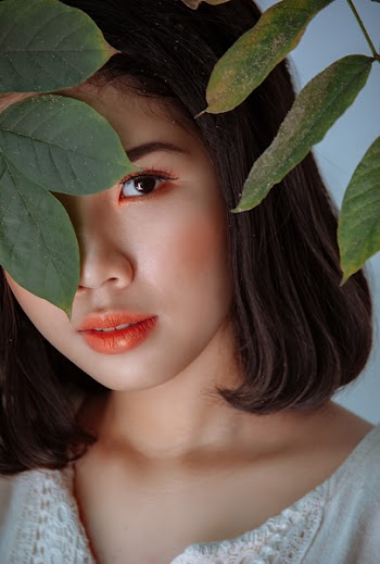 Photography Of Woman Hiding Behind Leaves